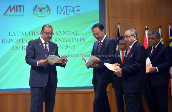 Ali Hamsa (left) and others take a closer look at the  ‘Annual Report on Modernisation of Regulations’ 2016 after launching  it at Bangunan Perdana Putra. — Bernama photo