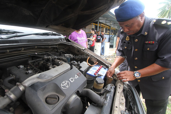 Jamal checking on a vehile in Kangar. — Bernama photo