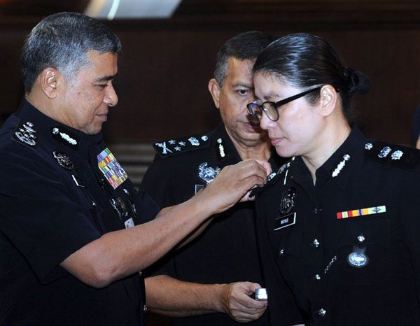 Khalid (left) pinning the ACP rank on Superintendant Wong Ing Fung at an event in Bukit Aman. — Bernama photo