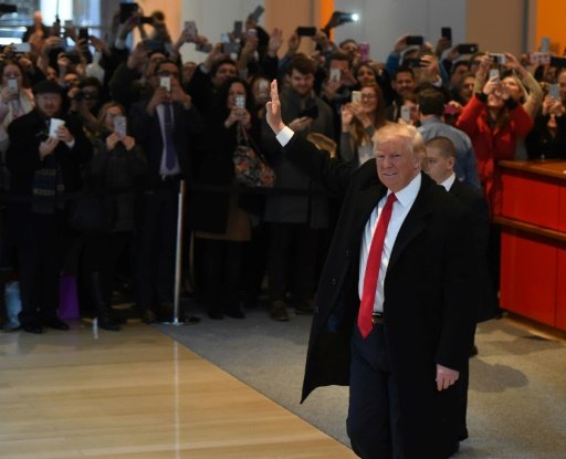 US President-elect Donald Trump waves to the crowd after leaving a meeting at the New York Times on November 22, 2016. - AFP