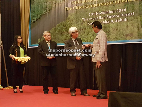 Sam (right) presenting a memento to Dr J. E. Ong, an expert on mangroves and wetlands at the launch of the second Sabah Ramsar Conference 2016 yesterday. 