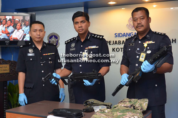 Chandra (centre) and police officers with the imitation guns that were confiscated from the suspect. 