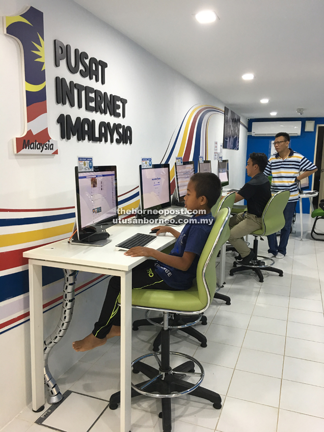 A young boy using the computer at PI1M Bandaria Park.