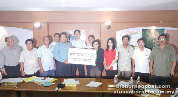 Chong (fifth right) presents the mock cheque to Bronnie.