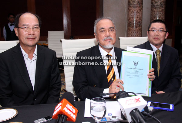 Asfia (centre) showing a copy of the Distribution of Gas Bill, 2016 which will be tabled during the DUN sitting. With him are Gerawat (left) and Sufian. — Photo by Chimon Upon 