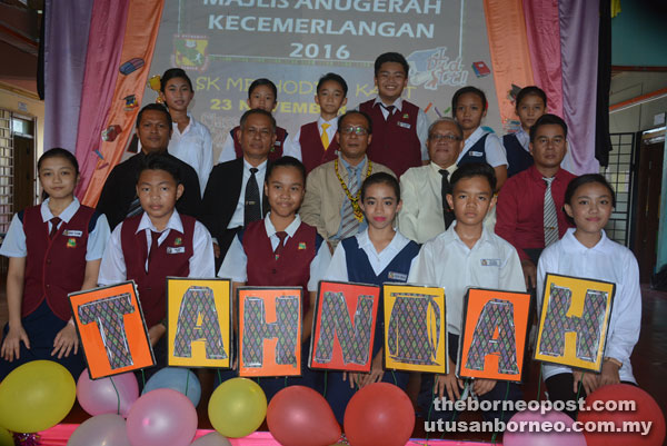 Philip (seated centre) is seen during a photo call with the UPSR high achievers. Demang is on his right.