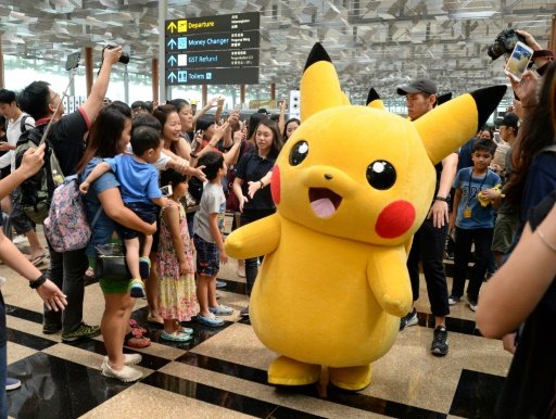 Fans gather to watch the Pokemon Go virtual reality game mascot Pikachu parade during a promotional event at the Changi International airport terminal in Singapore on November 18, 2016 -AFP photo