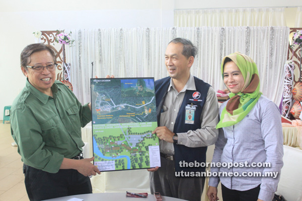 PEMBANGUNAN: Abang Johari menunjukkan pelan pembangunan di Semenanjung Santubong yang bakal disiapkan menjelang tahun 2019 sambil disaksikan Leh (dua kanan). 