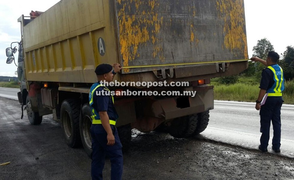 SUKAT: Dua anggota JPJ sedang memeriksa sebuah lori di salah satu lokasi operasi di sepanjang laluan Pan Borneo.