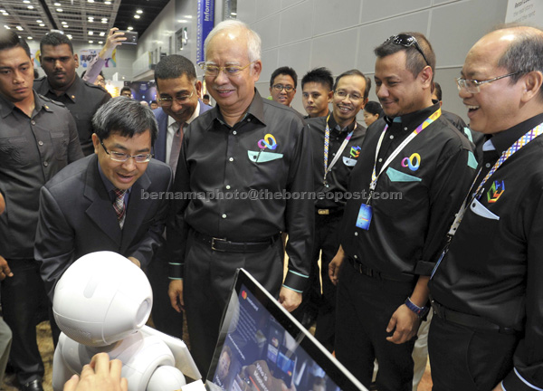 KAGUM: Najib bersama Madius (kanan) melihat robot bernama Meet Papper selepas merasmikan Majlis Kemuncak Tahunan Pengkomersilan di Pusat Konvensyen Kuala Lumpur hsemalam. — Gambar Bernama