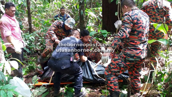 DITEMUI: Anggota penyelamat mengangkat mayat mangsa untuk dihantar ke hospital.