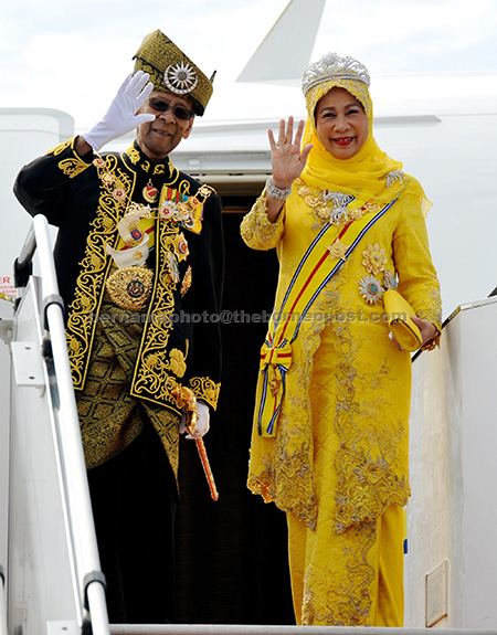 Tuanku Abdul Halim and Tuanku Hajah Haminah wave to the crowd before they enter the special aircraft taking them to Alor Setar.— Bernama photo