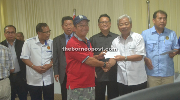 Ling Hang Kee, representing Malaysian Red Crescent Kapit Chapter, receives the MRP grant from Masing (sceond from right). With them are (from left) Elvis, Jamit, Joseph, Nanta and Ugak. 