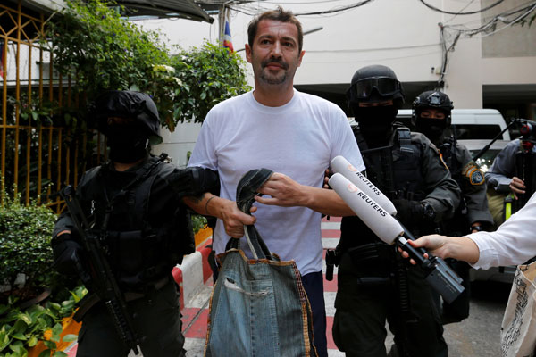 Justo is escorted by Thai police commandos as he arrives at the Immigration Detention Centre in Bangkok. — Reuters photo