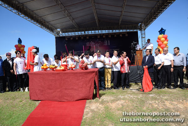 Abang Johari (fourth right) unveiling a filming camera while the cast and crew conduct a ritual for blessing.