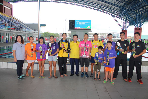 The best swimmers posing with Dr Sim (centre), organising chairperson Alice Kwon (left) and (from fourth right) Ivan Chu and Johnny Wong after receiving their trophies.