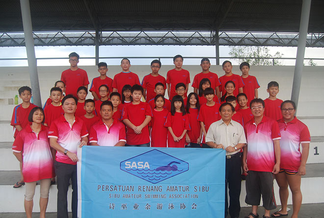 Sasa team manager Kong Sien Hock (second left) receives the colours from Sasa chairman Oliver Kuo (fourth left) at the flag handing-over ceremony at Bukit Lima swimming pool on Wednesday night. 