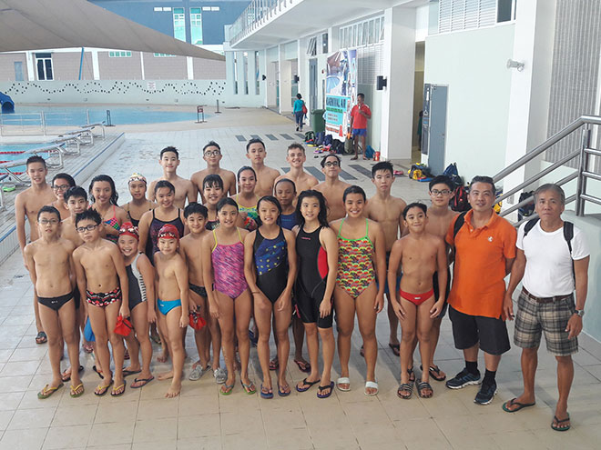 Swimmers of Sea Dragon Swimming Club with coach Jimmy Wong (right) and team manager Ivan Chu (second right) after a training session at Sarawak Aquatics Centre yesterday.