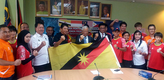 Manyin (centre), flanked by Abdul Karim (on his left) and Kameri, leading the delegation members to give a spirited pose during the handing over of state colours.