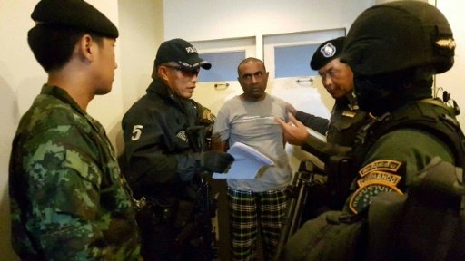 Pakistani national Abdul Rehman (C), was arrested in Bangkok and is suspected of being part of an extortion gang that burned down a Karachi factory in 2012 killing 259. AFP Photo