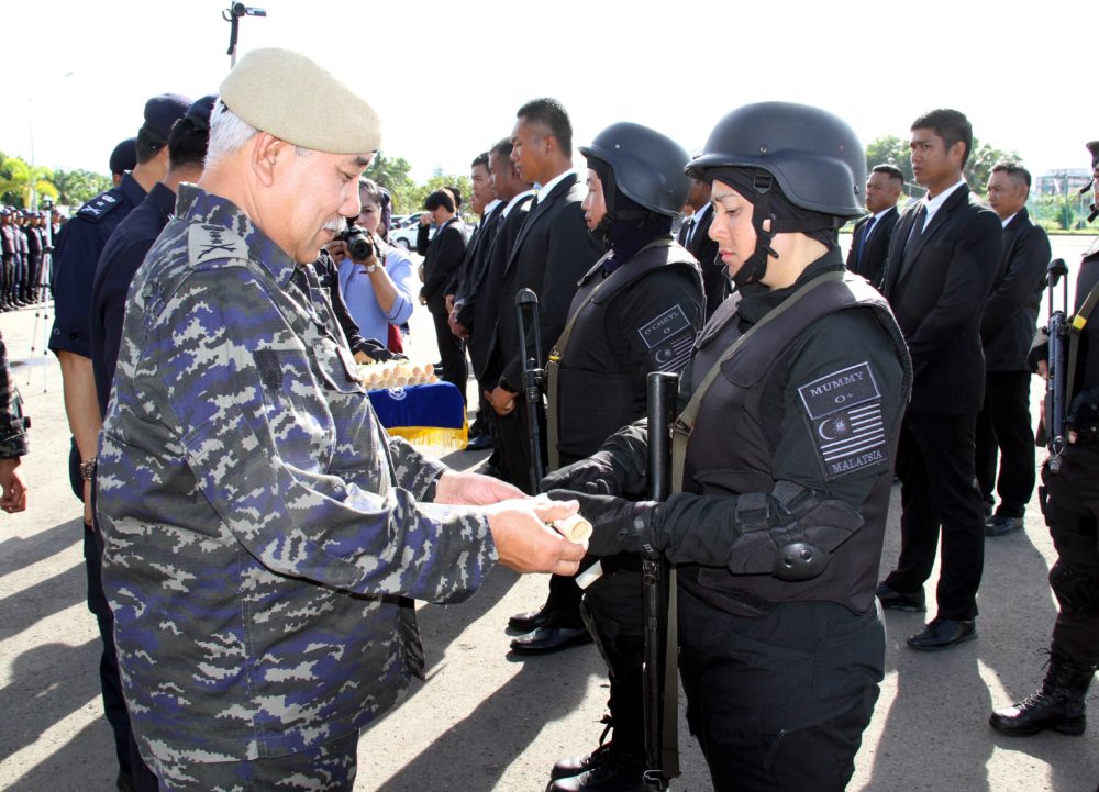 Abd Rashid Harun presents a certificate to security forces personnel at the event. Bernama Photo