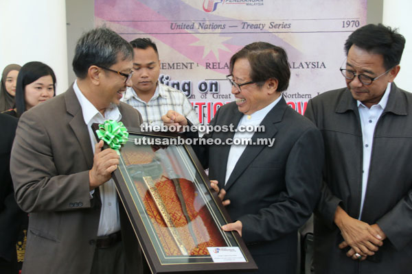 (From left) Abang Sardon presents a memento to Abang Johari at the start of the briefing in Sibu, as Abdul Karim looks on.