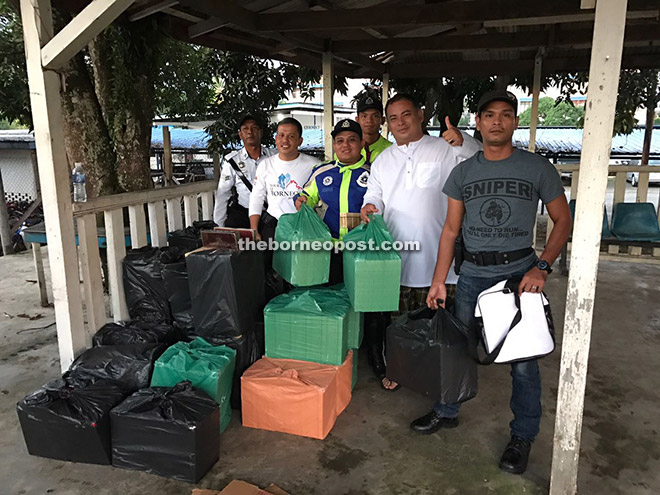 Mohd Nasaruddin (second right) with his man showing the seized items.
