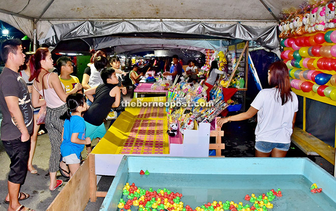 The kids accompanied by their parents having endless fun at one of the game stalls. 