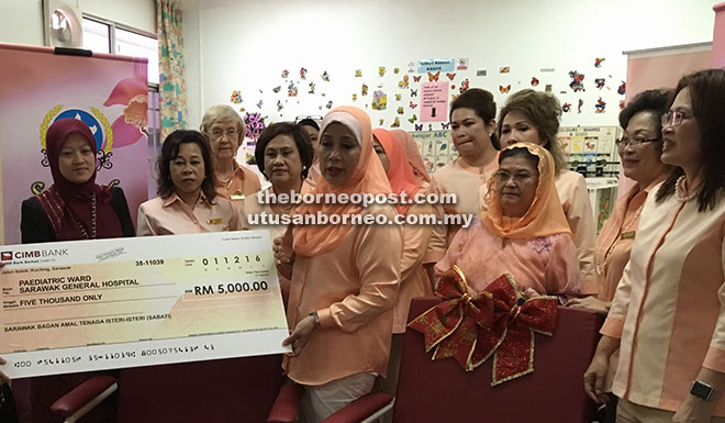 Jamilah (centre) presents a mock cheque for the donated amount as well as the reclining chairs to the hospital’s deputy director (Clinical) Dr Norinawaty Abang Daud (left) in the presence of Juma’ani (third right) and other Sabati members.