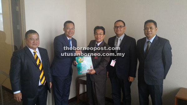 Mohd Isham (centre) presents the PPKS programme sheet to Abdullah. Witnessing this are Sadong Jaya assemblyman Aidel Lariwoo (right) and his counterpart for Balingian, Abdul Yakub Arbi (left).