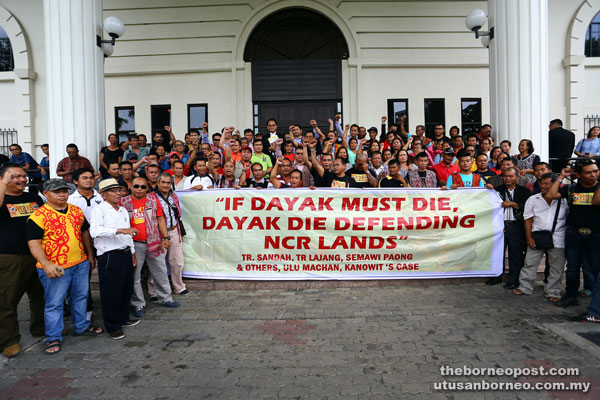 Baru (in suit, at back row) with supporters at the Kuching Courthouse. — Photo by Muhammad Rais Sanusi