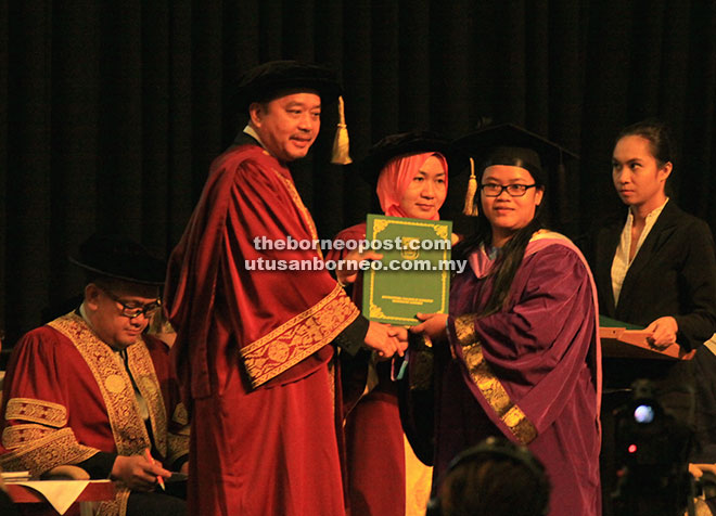 Abdul Aziz (left) handing over a certificate to a graduate. – Photos by Jeffery Mostapa