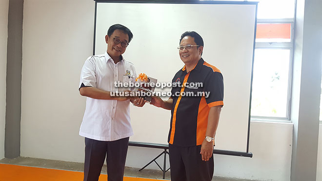 Abdul Karim (left) receiving a memento from Syeed Mohd during the event held at Centex Kuching, Jalan Sultan Tengah.