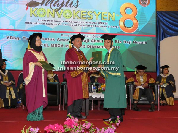 Abdul Aziz (centre) presents a diploma to BTEC HND Electrical/Electronic Engineering graduate Larry Laing Bit while Norashikin looks on. 