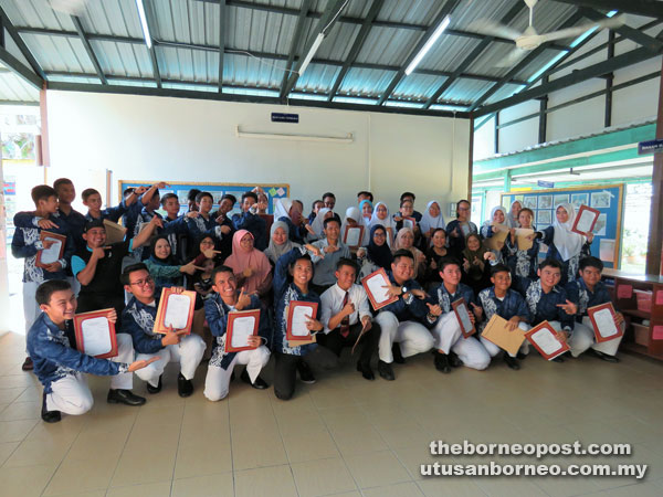 Mohd Dzul (seated, fifth right) and other SM Sains Miri teachers join their students including top-scorers Azahar (front, fourth right) and Fikri (front, sixth right) for a photo-call.