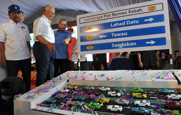 Najib and Sabah Chief Minister Datuk Seri Musa Aman (left) being briefed by Works Minister Datuk Seri Fadillah Yusof (right) during the launching of Pan Borneo Highway Lahad Datu By-Pass at Sekolah Menengah Kebangsaan Sepagaya in Lahad Datu. — Bernama photo
