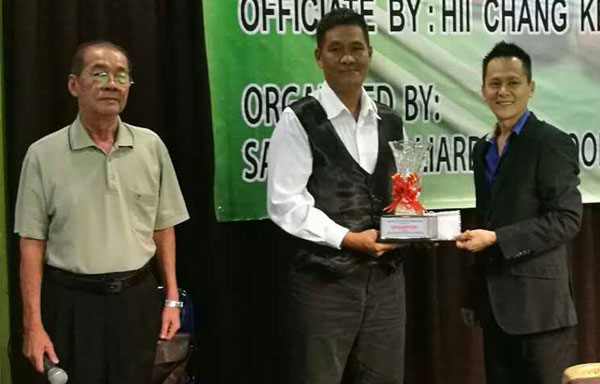 Ng (centre) receives the award from Yeo, who is also the managing partner of Executive 3 Snooker Centre. Looking on is tournament referee Danny Wong.