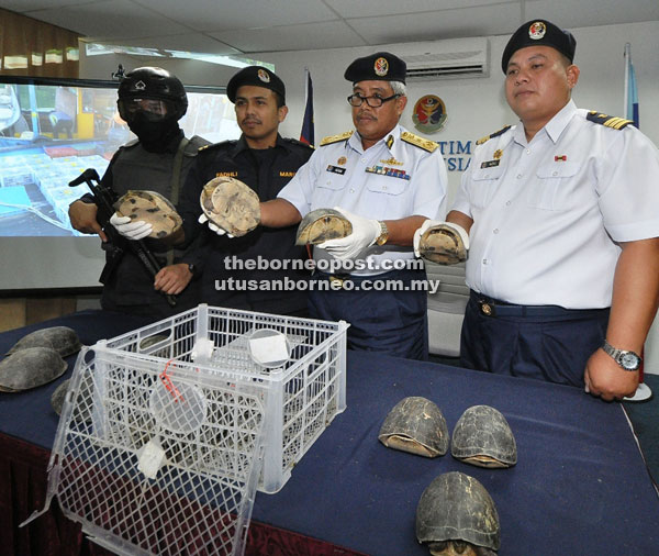 Adam (second right) and MMEA officers showing the seized turtles.