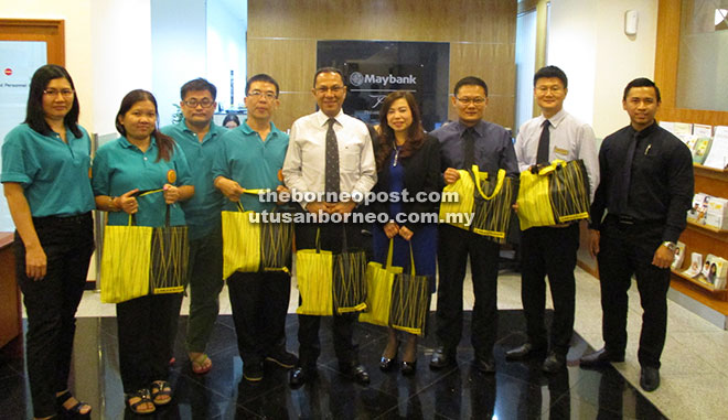 Nasir (centre) and Sim on his left join Billy (third right), Lik Khing (fourth left) and other representatives from Maybank Private and Premier Wealth Kuching Centre and the association for a photo-call. 