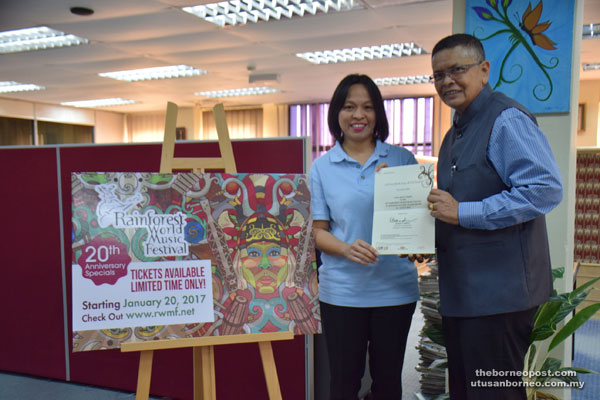 Sarawak Tourism Board (STB) Communications and Marketing Division manager Barbara Benjamin Atan (left) and BPIEF chairman Dorge Rajah hold the free pass for RWMF at STB office.