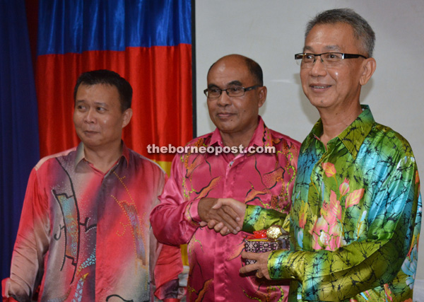 Abdul Mutalib (centre) presents a token of appreciation to Henry Ho, who is retiring this year. At left is Abdul Mutalif.