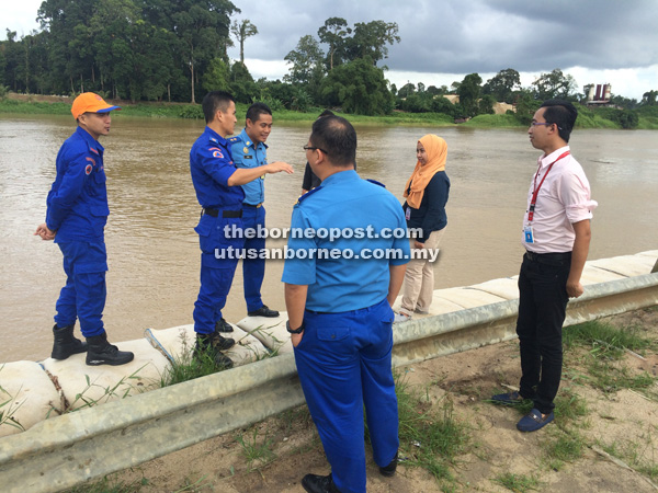 LAWAT: Awang Askandar dan anggota APM melawat ke setiap lokasi kerap banjir di Kuching semalam. Gambar diambil di tebingan Kampung Rantau Panjang.
