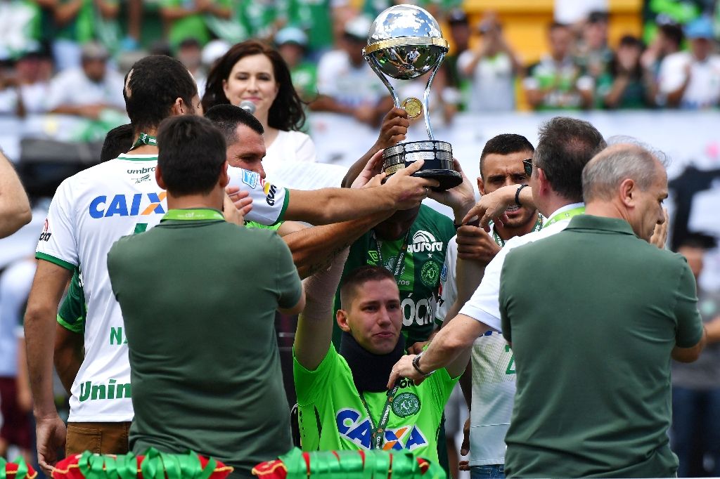 Brazilian Chapecoense goalkeeper Jackson Follmann (C), holds up the Copa Sudamericana trophy before a friendly match against Palmeiras. AFP Photo
