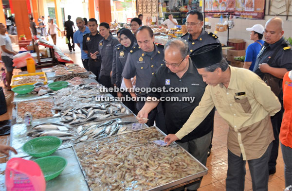 (From right) The state Federal Agricultural Marketing Authority (Fama) director Paza Dan takes Henry and his entourage from the state KPDNKK to the seafood section of the market.