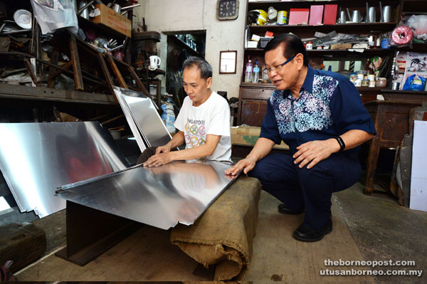 Lee (right) visiting a tinsmith during the Kuching Heritage Walk yesterday.