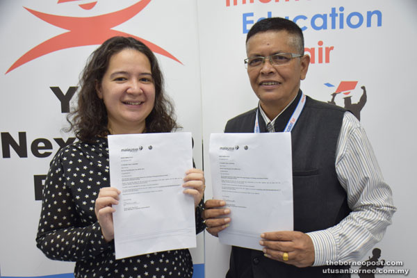 BPIEF chairman Dorge Rajah (right) and BPIEF committee member Margaret Apau holding the Malaysia Airlines Berhad letters of award for the complimentary tickets.