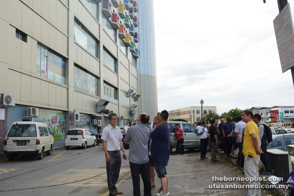 Occupants of Limbang Plaza seek safety outside the building.