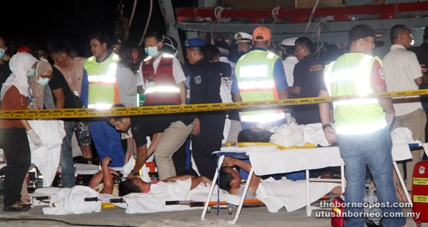 Some of the capsized catamaran victims arriving at the marine police jetty before being sent to Queen Elizabeth Hospital. — Bernama photo