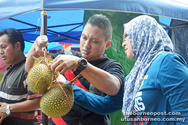 A couple takes a closer look at some durians at Layah’s stall.