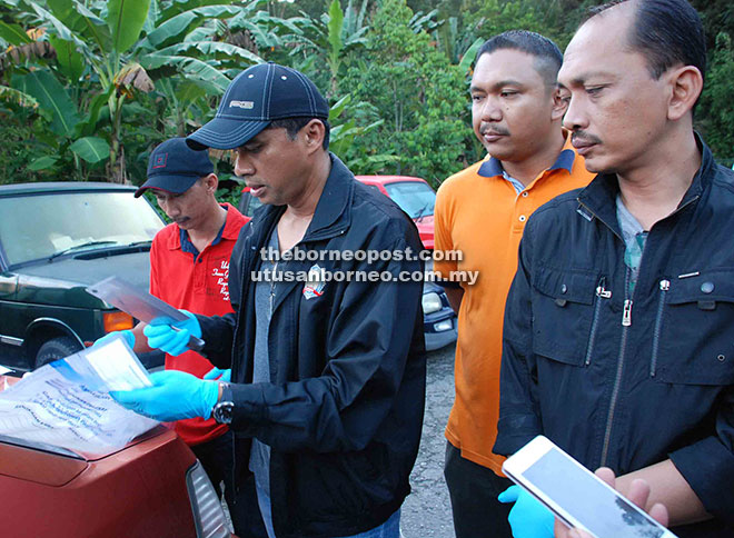 Chandra showing the cleaver that was used by the suspect to attack the police as CID chief DSP Nor Azizulkifli Mansor (right) and other police officers look on. 